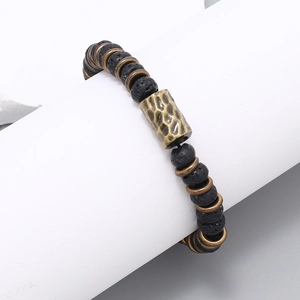 Close-up of black volcanic lava beads and hammered bronze metal bead on elastic bracelet
