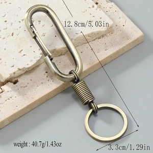 Vintage bronze car keychain with spring clip and leather texture on stone background