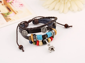 Detail of bohemian multilayer leather bracelet with Peace sign and Eiffel Tower charms