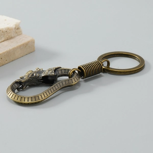 Detailed close-up of retro dragon head keychain hook with bronze alloy texture and scales