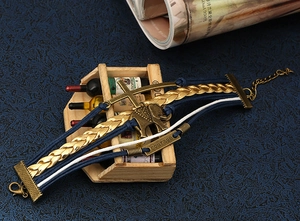 Détail d'un bracelet multicouche avec breloque éléphant, croix et plaque gravée courage