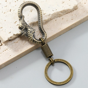 Macro view of vintage bronze dragon head carabiner keychain with metallic texture