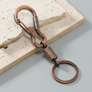 Detail of vintage bronze keychain with S-carabiner and lucky Chinese engraving