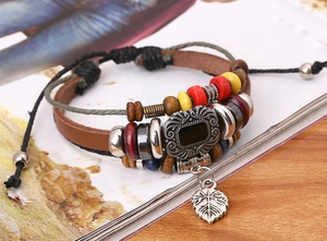 Macro detail of multi-layer leather bracelet with metallic leaf pendant and beads
