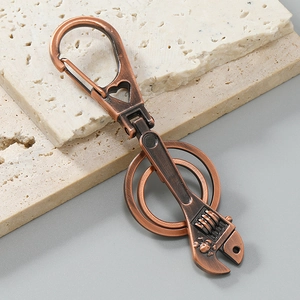 Macro detail of vintage bronze wrench keychain with skull charm on stone slabs