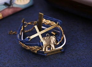 Vue détaillée du bracelet tressé rétro avec éléphant doré et plaque courage