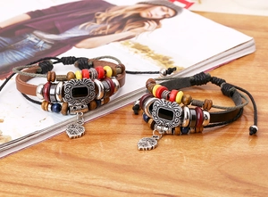 Detail of multi-layer leather bracelets with wooden beads and alloy leaf charms