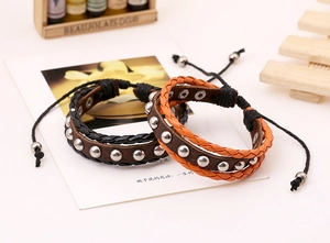 Detail of couple leather bracelets with silver studs and adjustable woven drawstring cord
