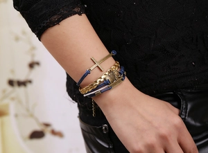 Détail d'un bracelet multicouche avec pendentif croix et gravure courage sur cordon bleu