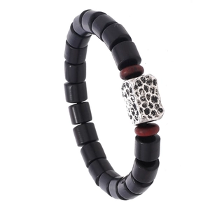 Minimalist vintage wooden bead bracelet featuring black cylindrical beads and silver hammered charm