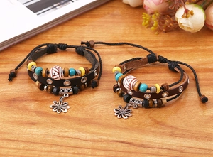 Detailansicht mehrlagiger Lederarmbänder mit bunten Holzperlen und Metallanhängern