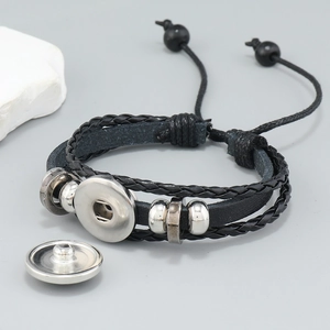 Detail of multi-layer black leather bracelet with silver snap base and beaded drawstrings