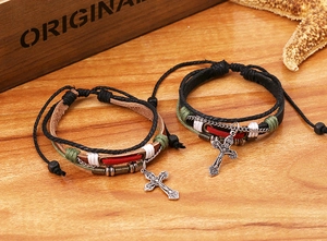 Détail de bracelets multicouches en cuir tressé vintage avec breloques en croix