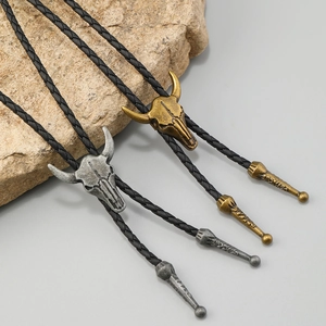 Vintage bull skull bolo tie with woven leather cord in antique silver and bronze finish