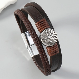 Vue macro de l'emblème de l'arbre de vie et du cuir tressé de ce bracelet pour homme