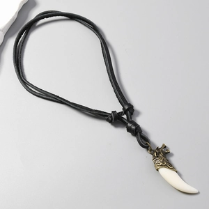 Détail du pendentif tête de loup avec charme en forme d'os sur cordon en cuir réglable