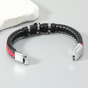 Detail view of woven leather bracelet featuring silver anchor charm and magnetic clasp