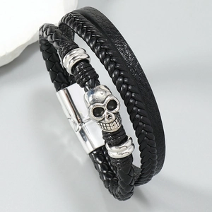 Detail of men's leather bracelet with silver skull charm and magnetic clasp
