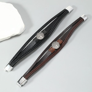 Détail de bracelets en cuir tressé multicouche avec breloques Arbre de Vie et fermoirs