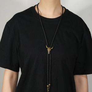 Retro bull head skull bolo tie with black braided leather cord and gold metal pendant