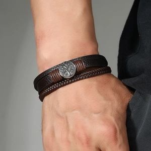 Gros plan détaillé du bracelet en cuir multicouche avec un charm Arbre de Vie sculpté