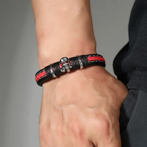 Men's punk leather bracelet with skull charm and red braided rope on wrist