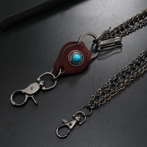 Detail of vintage punk leather wallet chain with gun-black metal layers and turquoise