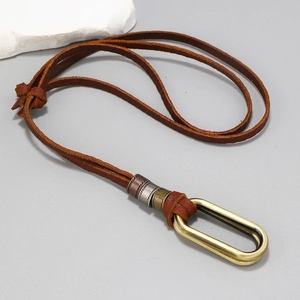 Detail of vintage brown leather sweater necklace with retro metallic beads and U-shaped pendant