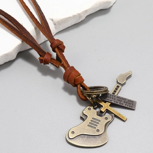 Macro shot of retro leather necklace featuring bronze guitar pendant and engraved plate