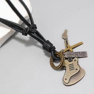 Detail of vintage guitar pendant and cross on adjustable black leather cord necklace