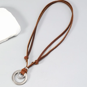 Detail of vintage brown leather necklace featuring matte brushed double ring pendants