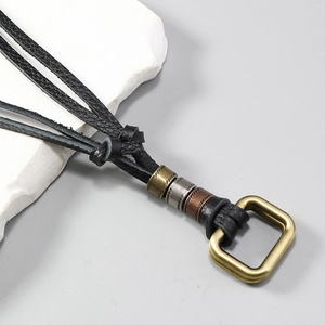 Detail of braided black leather cords with vintage bronze bead accents and gold ring buckle