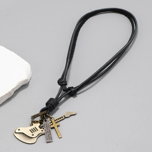 Detail of vintage bronze guitar pendant and cross on black braided leather cord necklace