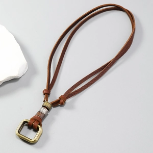 Detail of vintage brown leather necklace featuring brass metal buckle and carved beads
