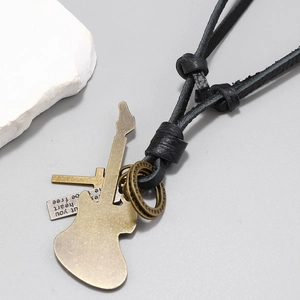 Macro detail of retro guitar and cross pendants on black leather cord necklace
