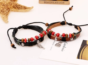 Detail of handcrafted leather bracelets with beads, metal key and lock charms