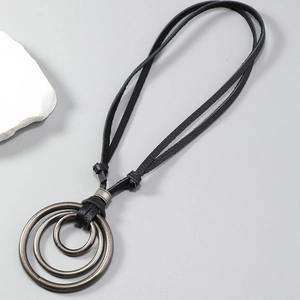 Détail de trois anneaux concentriques sur un collier réglable en cuir noir rétro