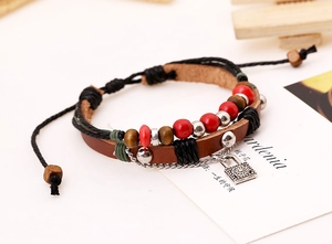Detail of multi-layer beaded leather bracelet with sun pendant and wooden beads