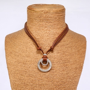 Detail shot of vintage cowhide necklace with double circle pendant on a rustic bust