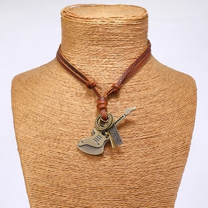 Close-up of guitar pendant leather necklace with vintage bronze engraving and hand-knotted cord