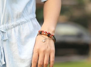 Close-up of bohemian multilayer leather bracelet with beads and padlock pendant