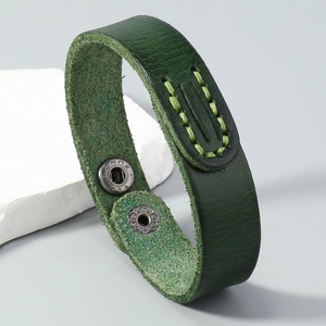Close-up of handmade dark green leather bracelet with light stitching and metal snaps