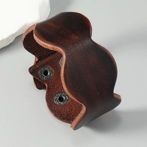 Detail of vintage brown leather cuff bracelet with adjustable metal snap fasteners