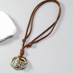 Detail of vintage layered brown leather cord necklace with interlocking metal rings