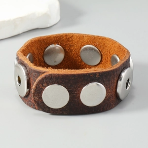 Detailed close-up of dark brown leather bracelet featuring circular silver metal studs