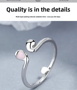 Détail macro d'une bague ouverte en argent S925 avec goutte en émail rose
