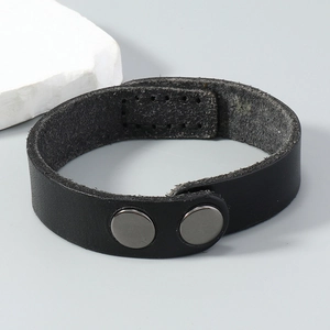 Detailed close-up of handmade black leather bracelet showing stitching and snap closures