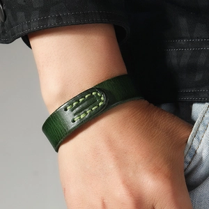 Vintage dark green handmade leather bracelet with stitching for men shown on wrist