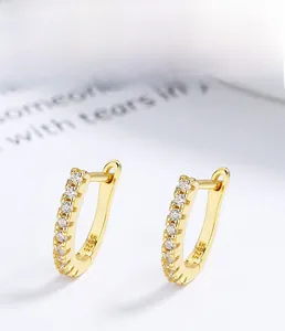 Macro view of gold S925 sterling silver J-hoop earrings with sparkling zircon stones
