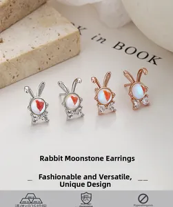 Macro detail of 925 sterling silver rabbit earrings with moonstone and carrot inlay